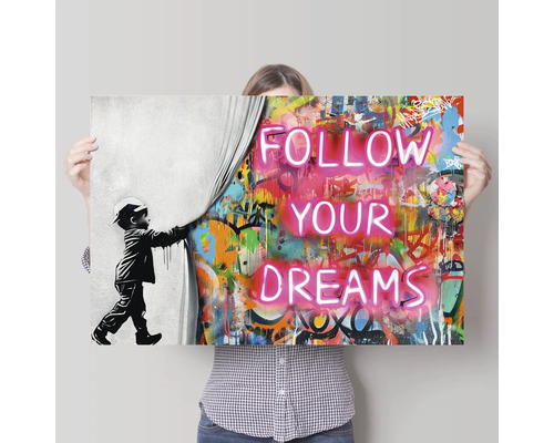 Wandbild mit der Aufschrift Folge deinen Träumen, eine Person hält das Bild hoch