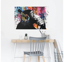 Dekoratives Wandbild mit einem Affen mit Kopfhörern über einem Schreibtisch