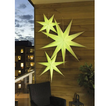 Dekorative Papiersterne hängen an einer Holzwand auf einem Balkon.