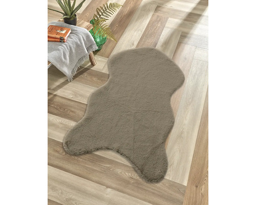 Dekorativer Teppich in unregelmäßiger Form auf einem Holzboden