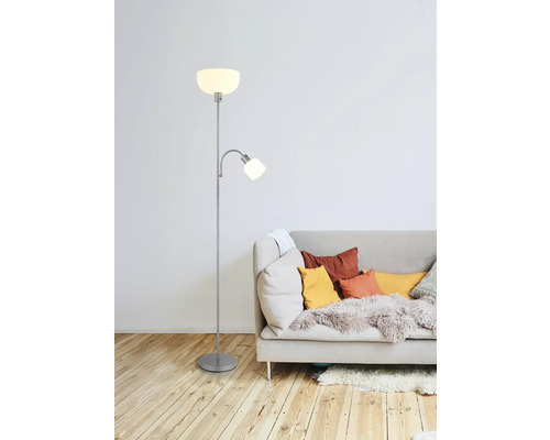 Stehlampe mit Leselampe neben einem Sofa mit Kissen