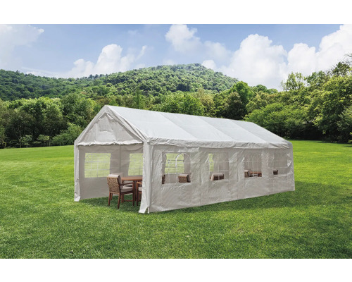 Weißes Partyzelt mit Fenstern und Sitzgruppe auf einer grünen Wiese.