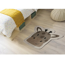 Zimmer Szene mit Bett, Sitzkissen und einem Teppich in Form eines Giraffenkopfes.