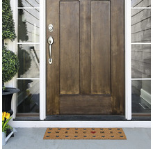 Fußmatte mit Willkommensgruß vor einer Haustür