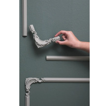 Wandpaneele mit Zierelementen und Hand auf grauer Wand