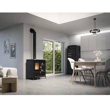 Wohnraum mit Holzofen, Esstisch, Stühlen und Kühlschrank.