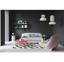 Wohnzimmer mit Sofa, Sessel, Teppich, Tisch und Wandregal.