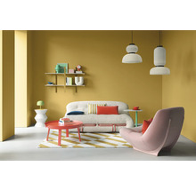 Wohnzimmer mit Sofa, Sessel, Tisch, Regalen und Pendelleuchten vor gelber Wand