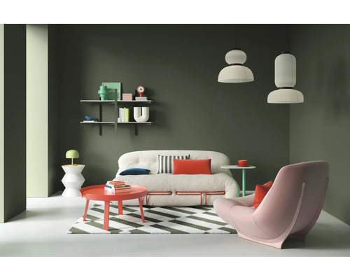 Wohnzimmer mit Sofa, Sessel, Couchtisch, Regalen und Pendelleuchten