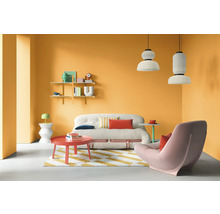 Wohnzimmer mit Sofa, Sessel, Teppich und Dekoration vor orangefarbener Wand