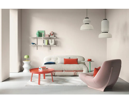 Helles Wohnzimmer mit Sofa, Sessel, Couchtisch und Regalen