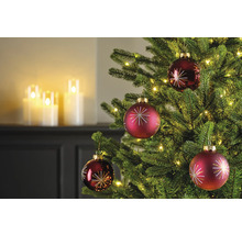 Nahaufnahme eines Weihnachtsbaums mit roten Christbaumkugeln und Lichtern