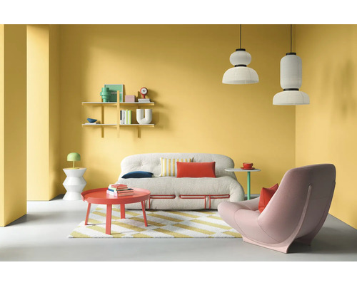 Wohnzimmer mit Sofa, Sessel, Tisch, Regalen und Lampen