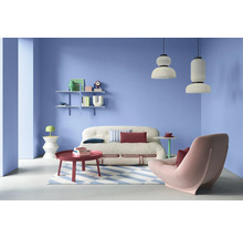 Wohnzimmer mit Sofa, Sessel, Couchtisch, Regalen und Pendelleuchten in einem hellen Raum