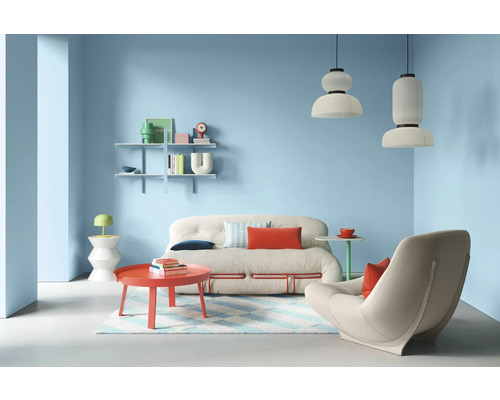 Wohnzimmer mit Sofa, Sessel, Tisch, Regalen und Pendelleuchten