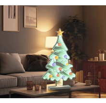 Dekorativer Weihnachtsbaum mit Sternspitze und Kugeln auf Tisch