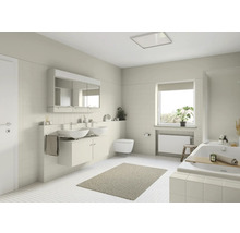 Helles Badezimmer mit Waschtisch, Spiegel, Toilette und Badewanne.