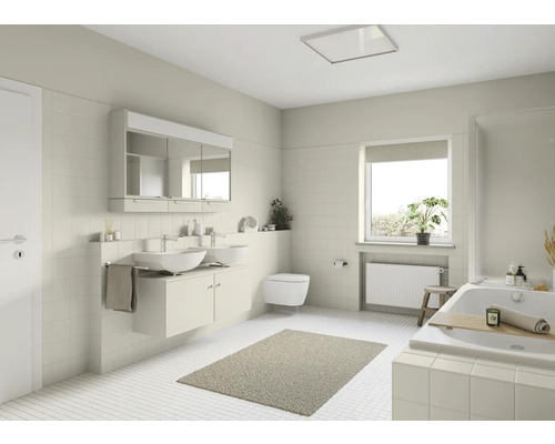 Helles Badezimmer mit Waschtisch, Spiegel, Toilette und Badewanne.