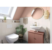 Badezimmer mit Toilette, Waschtisch, Spiegel und Dekoration unter Dachschräge