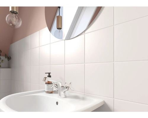 Helles Badezimmer mit Waschbecken, Armatur und quadratischen Wandfliesen