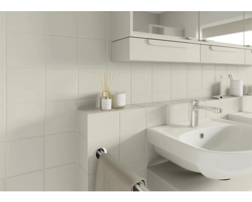 Badezimmer mit Waschbecken, Armatur, Handtuchhalter und quadratischen Wandfliesen