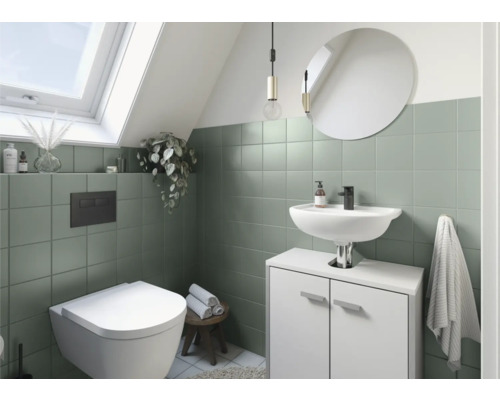 Badezimmer mit Dachfenster, Toilette, Waschtisch, Spiegel und grünen Fliesen