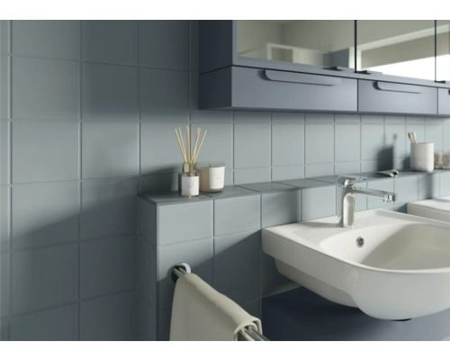 Badezimmer mit Waschtisch, Armatur, Spiegel und Ablagefläche