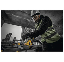 Mann mit Schutzhelm und Schutzbrille bedient eine Handkreissäge der Marke DeWalt auf einer Baustelle