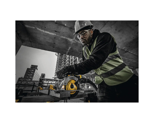 Mann mit Schutzhelm und Schutzbrille bedient eine Handkreissäge der Marke DeWalt auf einer Baustelle
