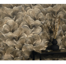 Detailaufnahme einer Wand mit floral gemusterter Tapete und einem kleinen Tisch mit Dekoration