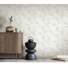 Raumansicht mit einem Schrank, einer Dekoration und einer Tapete mit Blättermuster