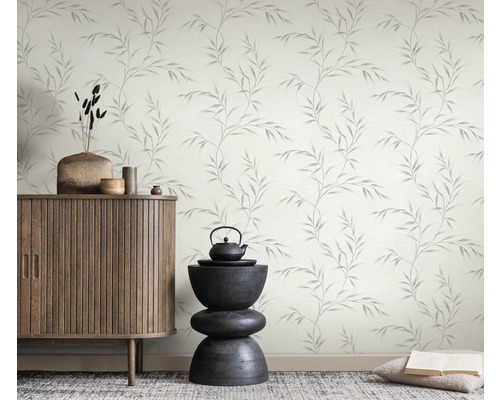 Raumansicht mit einem Schrank, einer Dekoration und einer Tapete mit Blättermuster