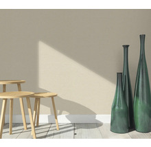 Szene mit drei Holzhockern und drei schlanken Dekovasen auf einem Holzboden vor einer Wand