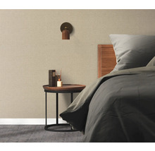 Schlafzimmer mit Bett, Nachttisch, Wandleuchte und Textiltapete