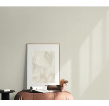 Dekoratives Wohnambiente mit gemusterter Tapete, gerahmtem Bild und dekorativer Figur