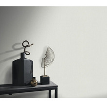 Nahaufnahme einer strukturierten Wand mit Dekorationsgegenständen auf einem Regal.