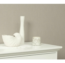 Dekorative Elemente auf einer Kommode vor einer Tapete