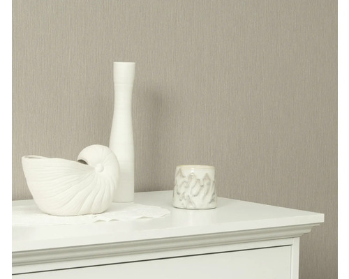 Dekorative Elemente auf einer Kommode vor einer Tapete