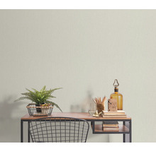 Schreibtisch mit Dekoration und Textiltapete im Hintergrund