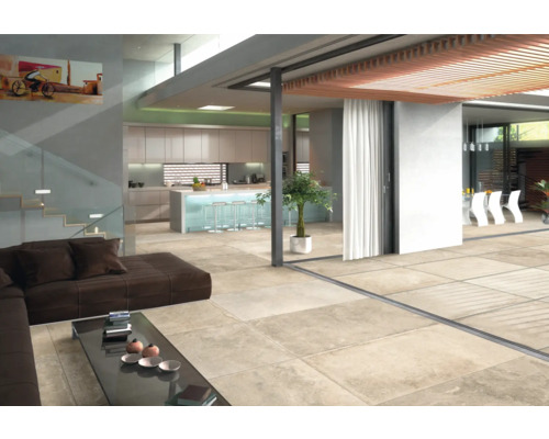 Heller Wohnraum mit Fliesenboden, Sofa, Tisch und Küchenbereich.