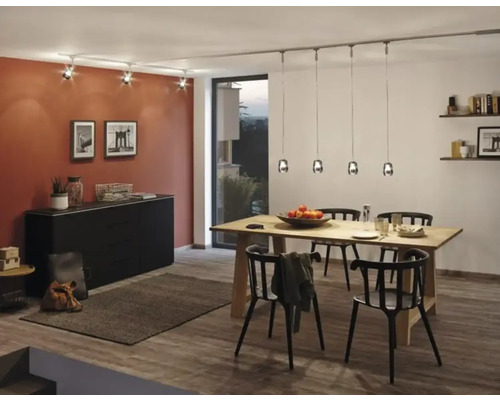 Esszimmer mit Holztisch, schwarzen Stühlen, Kommode und Beleuchtungssystem