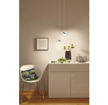 Helles Interieur mit Sideboard, Sessel und Pendelleuchten für eine freundliche Atmosphäre.