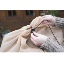 Person zieht die Kordel einer Schutzhülle fest