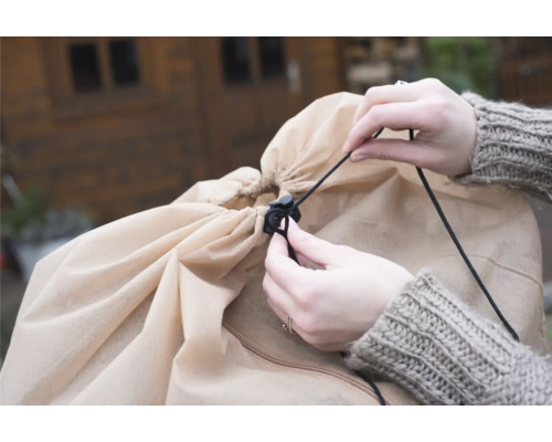 Person zieht die Kordel einer Schutzhülle fest