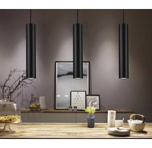 Drei schwarze Pendelleuchten über einem Tisch in einem Esszimmer.