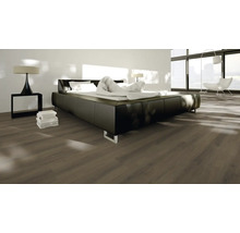 Schlafzimmer mit Laminatboden, Bett und Nachttischlampe.