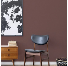 Wohnzimmer mit Kommode, Stuhl und Weltkarte an der Wand