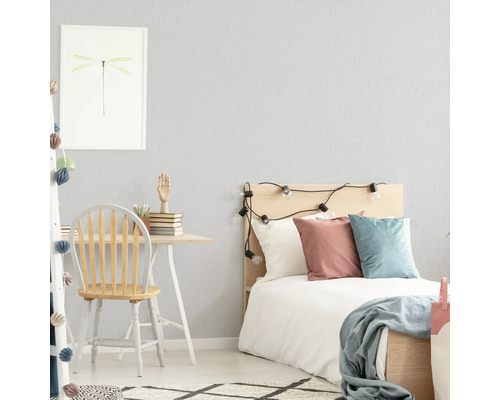 Helles Schlafzimmer mit Schreibtisch, Stuhl und Bett.