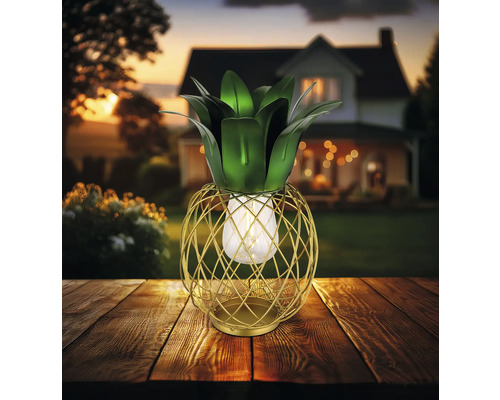 Ananasförmige Dekorationsleuchte aus Metall für den Außenbereich auf einem Holztisch