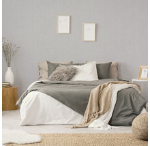 Schlafzimmer mit Bett, Nachttisch und gemusterter Tapete